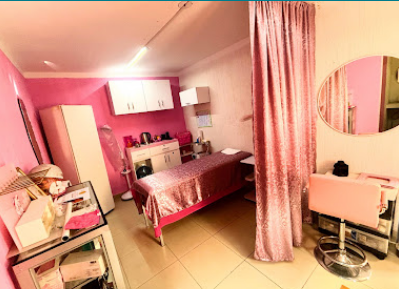 Sala de tratamiento con camilla y cortina rosa de La Cabina Spa VIP